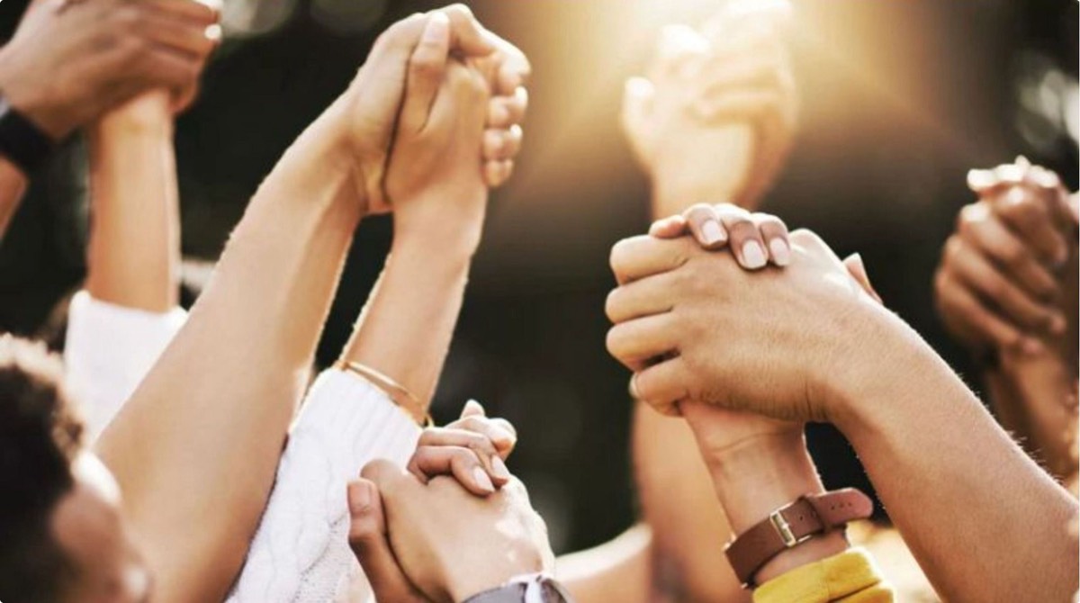 Hands of many women joined together in community